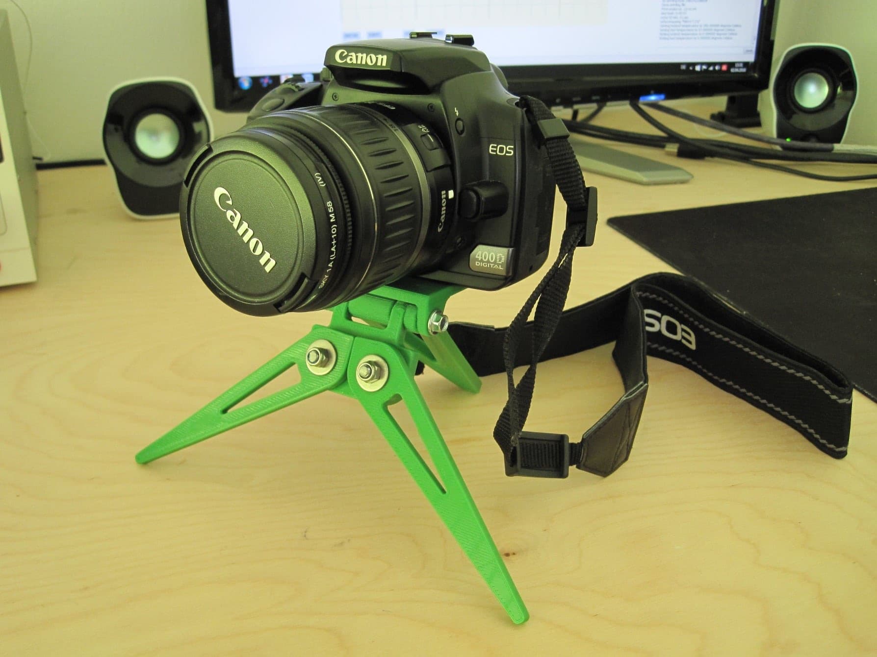 Folding camera tripod deployed with a DSLR mounted